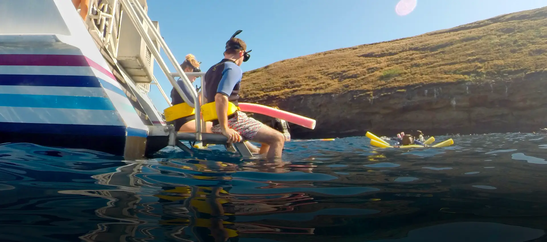 Divers get ready to enter the water with pool noodes.